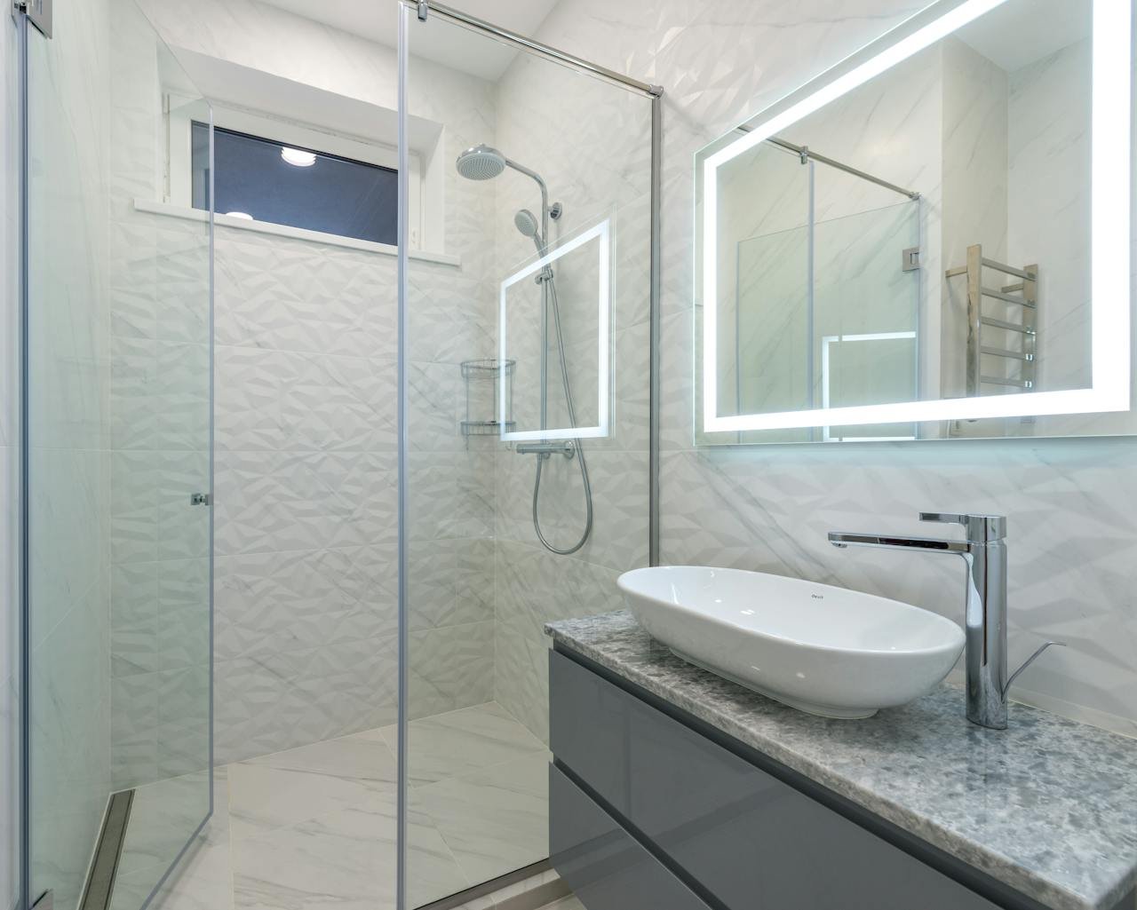 gallery-2 Stylish mirror illumination shining in bathroom above sink with faucet and shower cabin